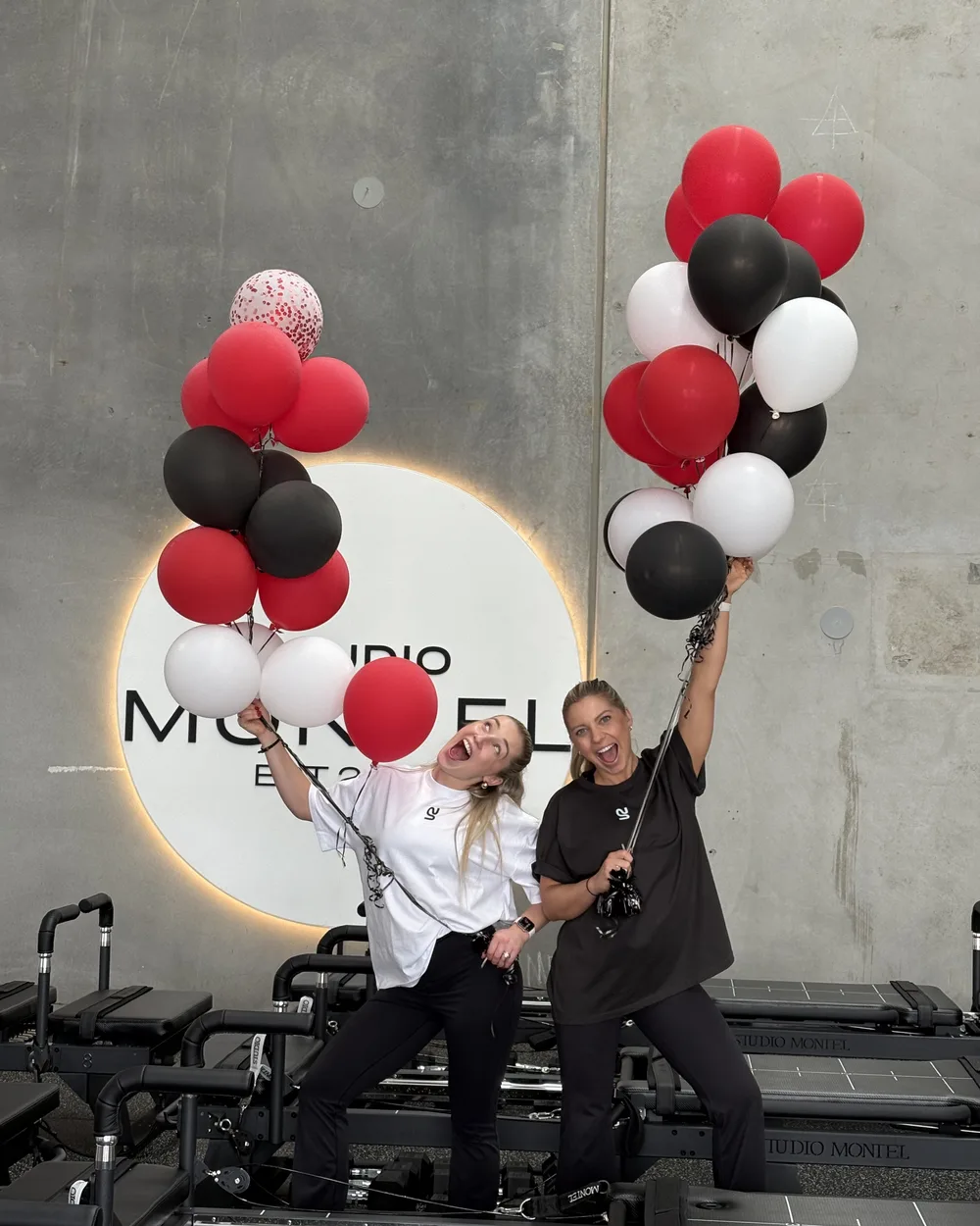 Studio Montel founders celebrating with red, black and white balloons in the studio